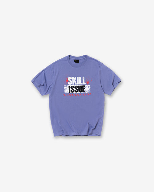 An Iris Blue short-sleeve t-shirt with a graphic on the chest reading 'SKILL ISSUE' in white, red, and black, displayed flat against a light gray background.