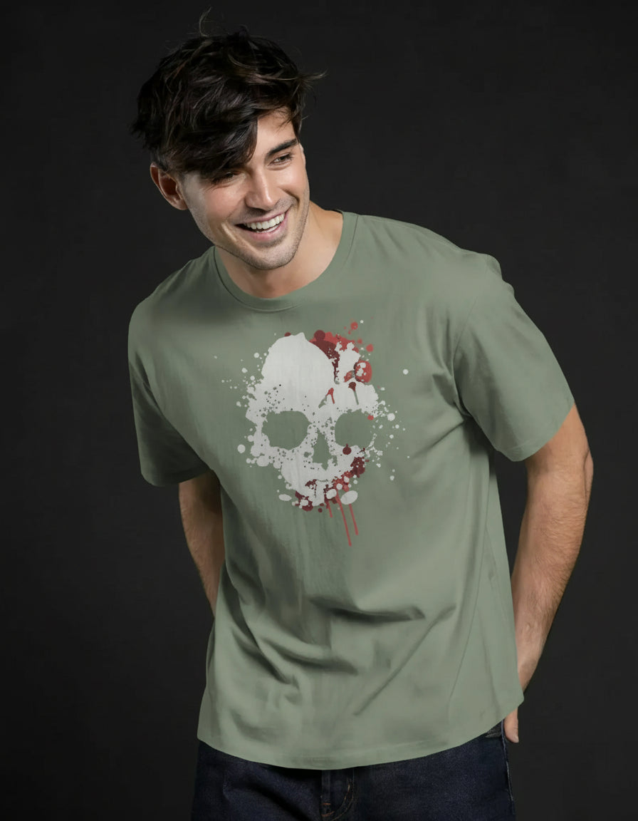 Man wearing a green t-shirt with a skull design on a dark black background
